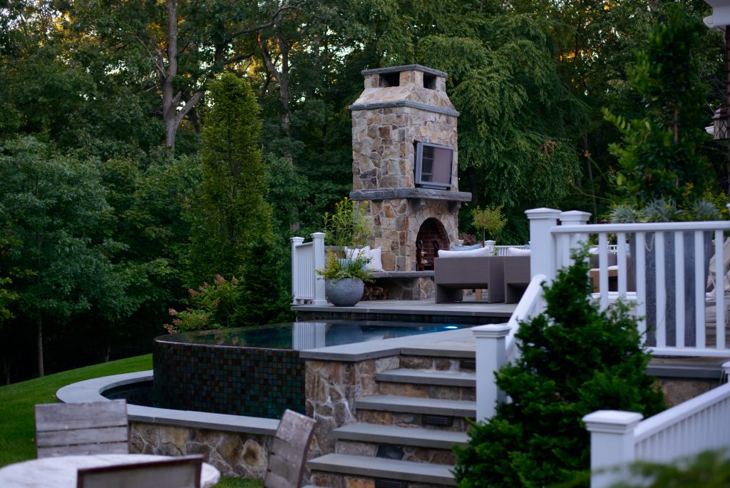 luxury cocktail pool design with fire place and stone stairs