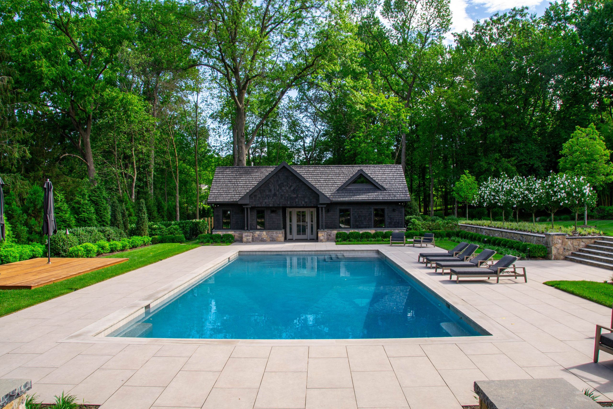 Gunite geometric pool design with patio and pool cabana
